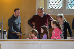 Steve shows a stopped pipe to young visitors