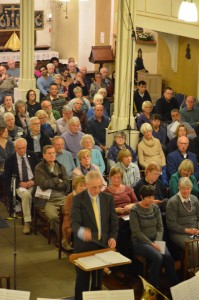 Bill Strang conducting the Rutter Gloria with audience behind him