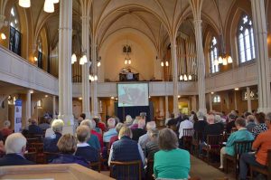 Large audience listening to organ and cello music